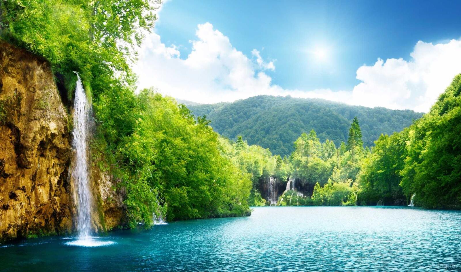 Бесплатное фото Водопад на озере летним солнечным днем