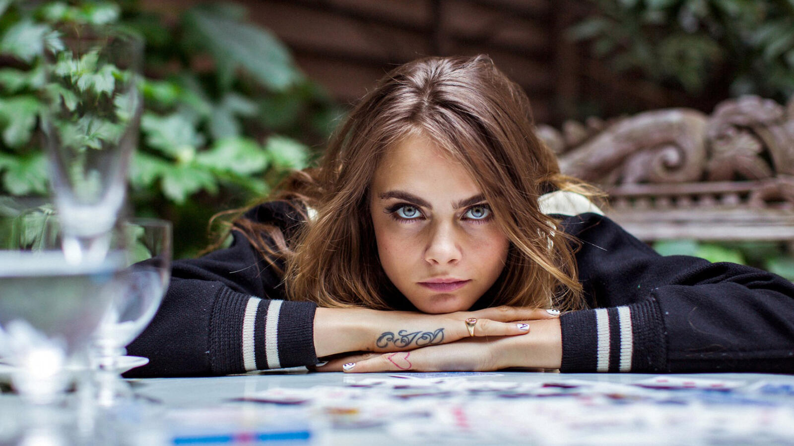 Free photo Cara Delevingne sits at a table in a restaurant