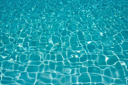 Вода в бассейне переливается под солнечными лучами