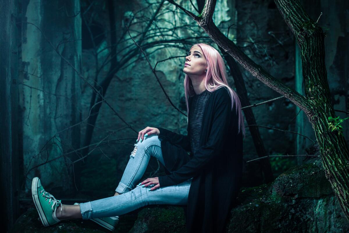 Девушка с розовыми волосами в мрачном лесу