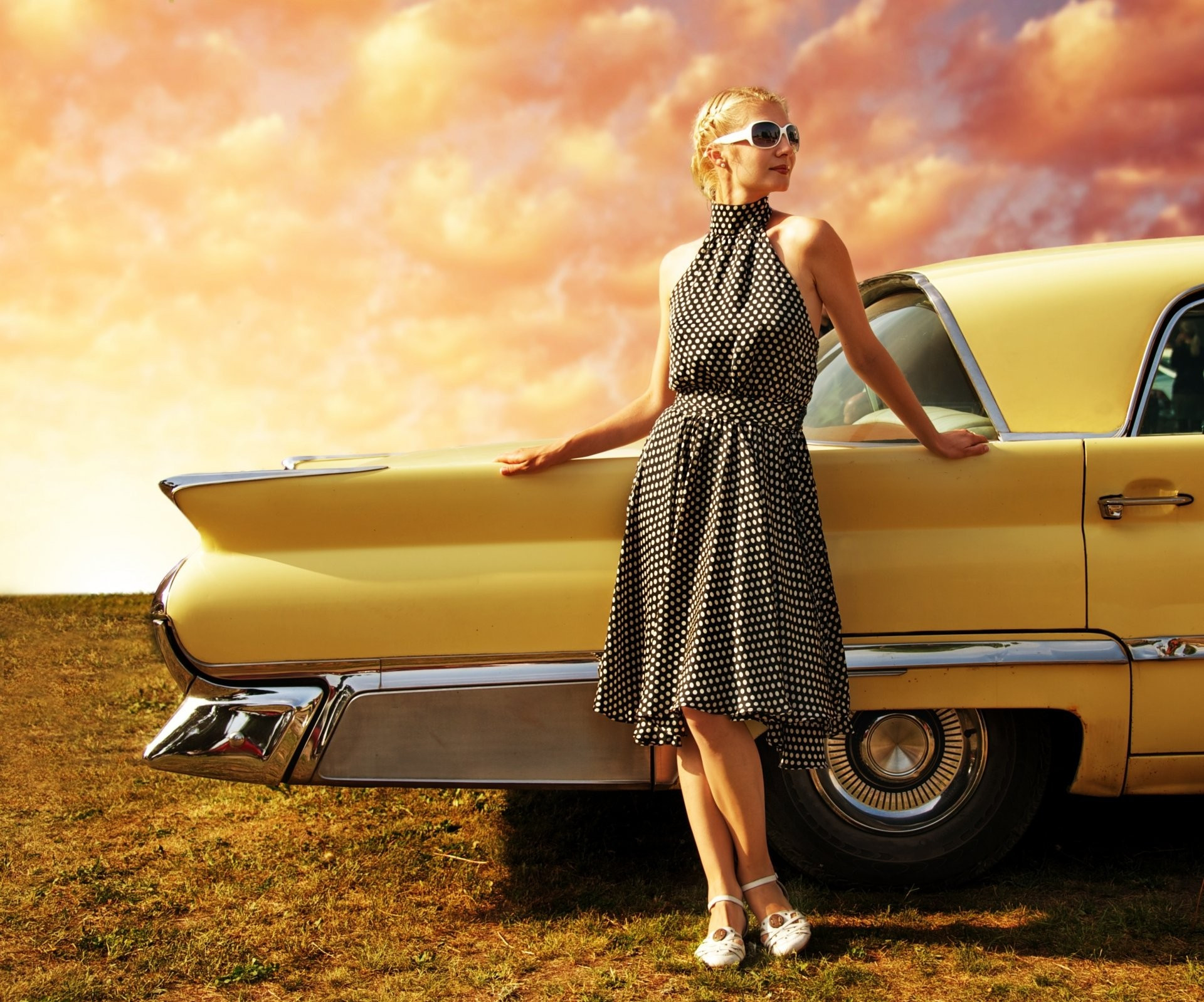 免费照片穿着波尔卡圆点连衣裙的女孩在一辆复古汽车前。
