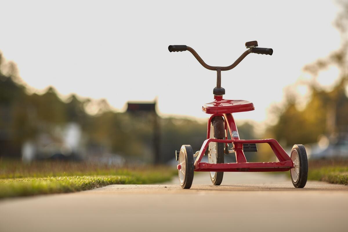 Children`s tricycle in red color