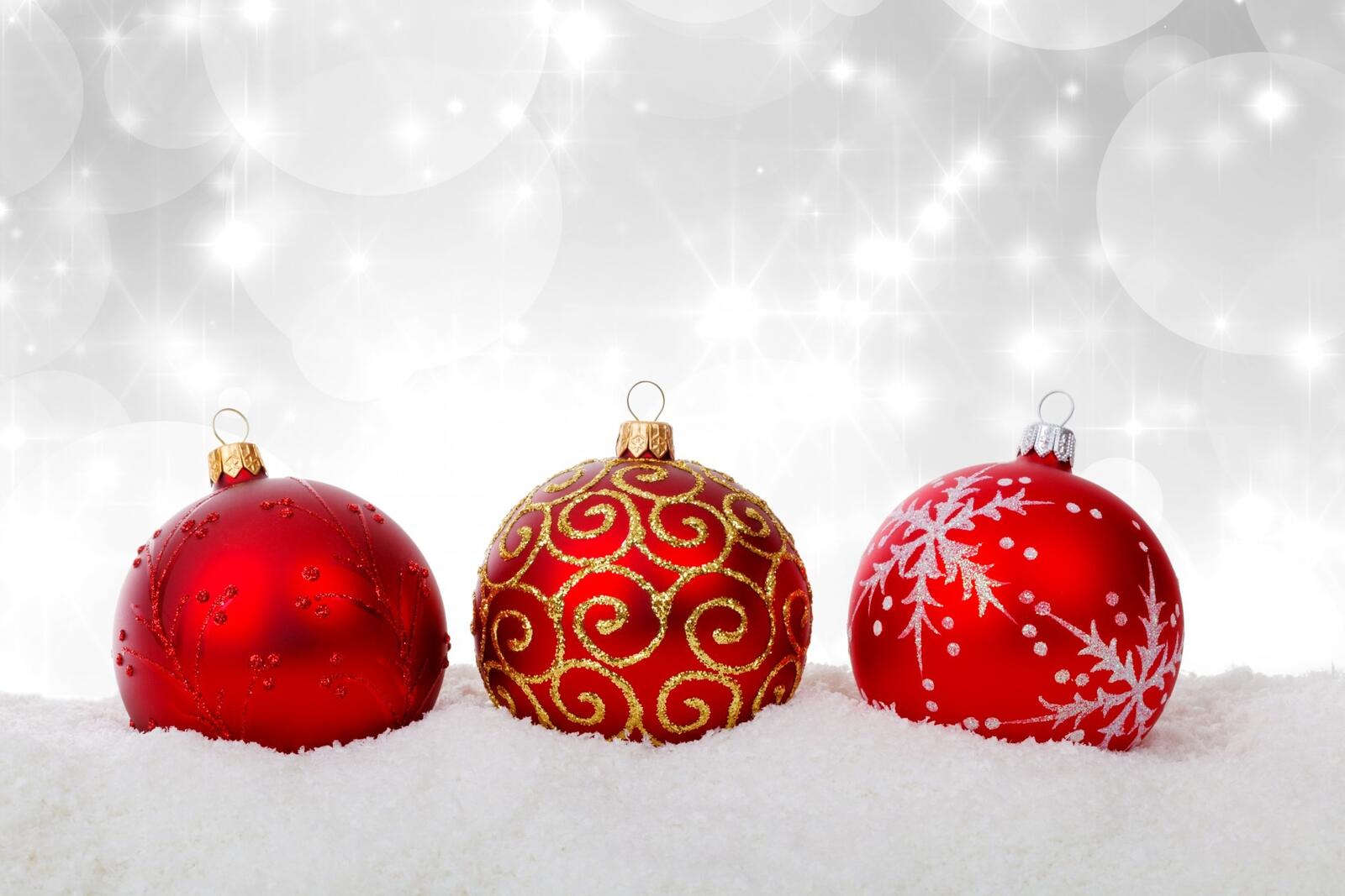 Бесплатное фото Три красных новогодних игрушки в снегу