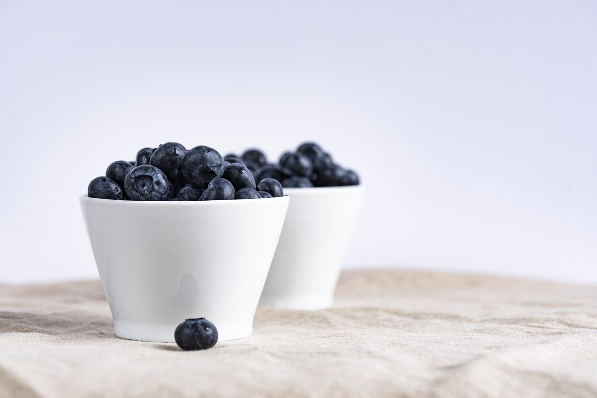 A picture of two white plates of blueberries