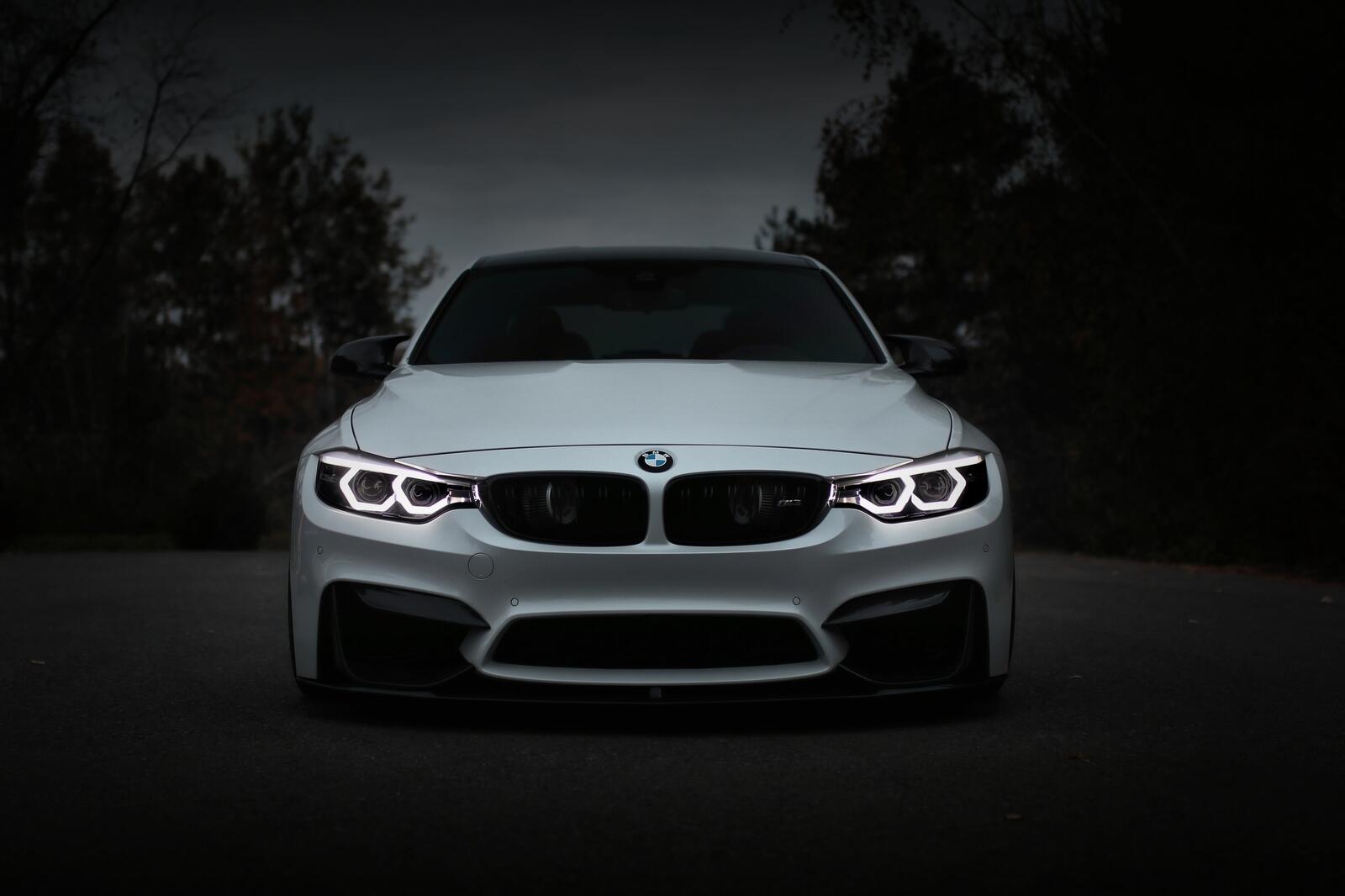 Бесплатное фото Белый BMW M3 на габаритах в темную ночь