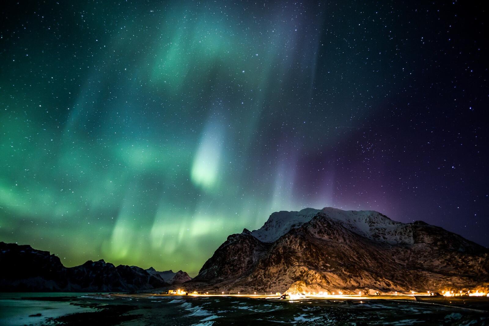 Free photo Northern Lights over the mountain by the lake