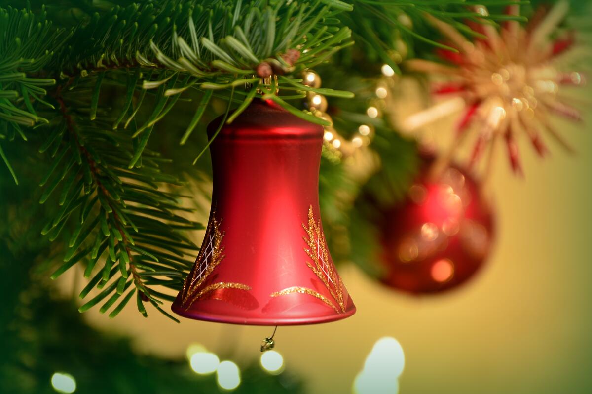 A red bell decorates the Christmas tree