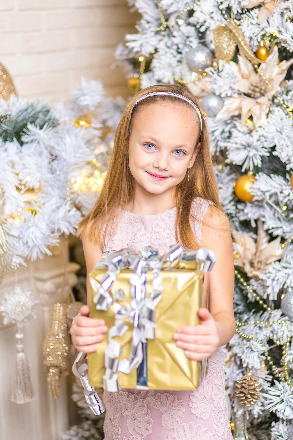 Девочка в платье с большим новогодним подарком