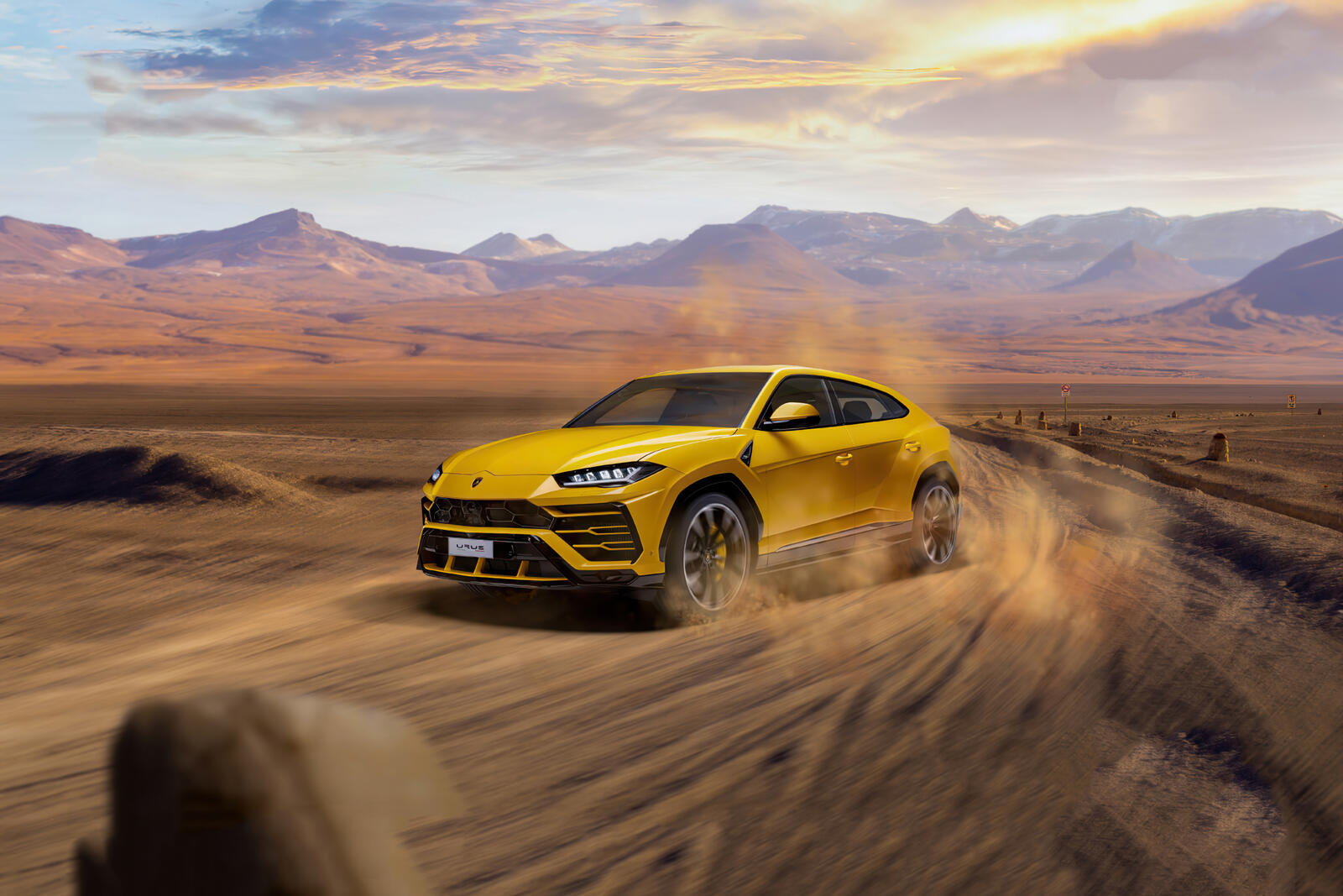 Бесплатное фото Желтый Lamborghini Urus едет по пыли