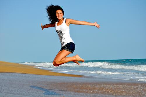 A girl gets excited and jumps on the beach