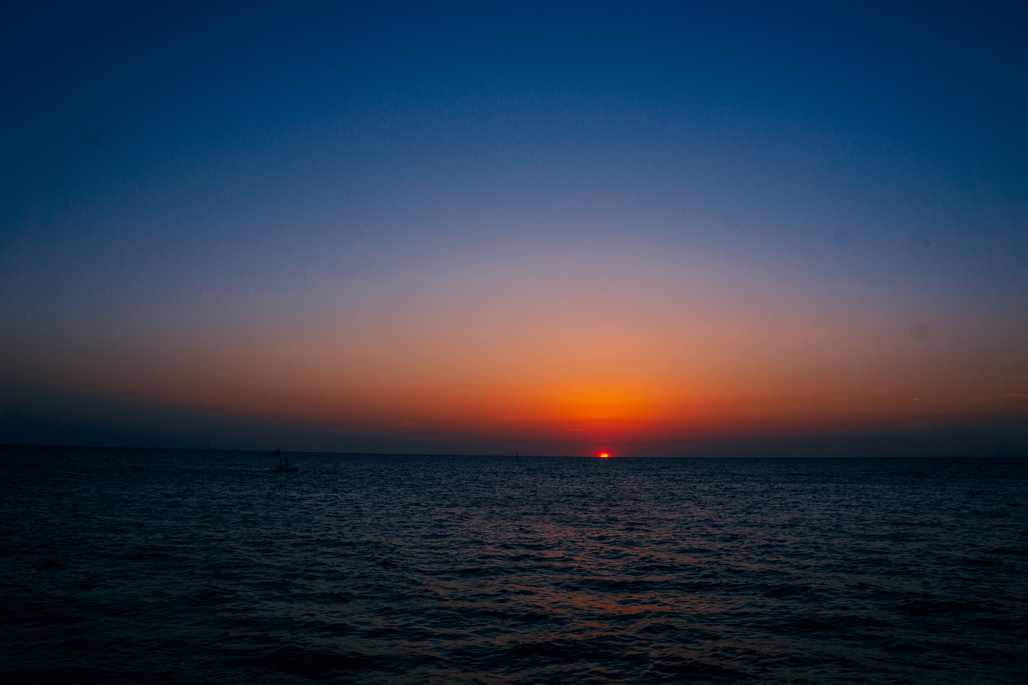 Free photo The receding sun over the horizon of the sea