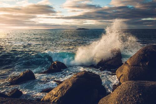 Sea waves crash against the rocks of the shore