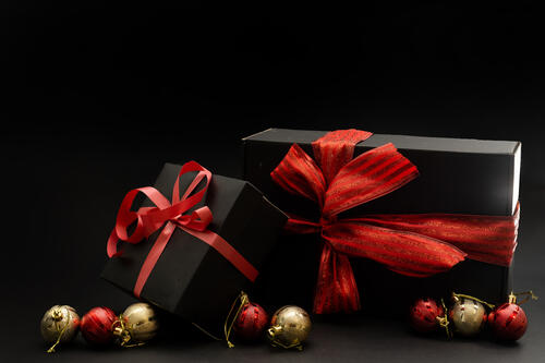 New Year`s gifts in black boxes with red bows
