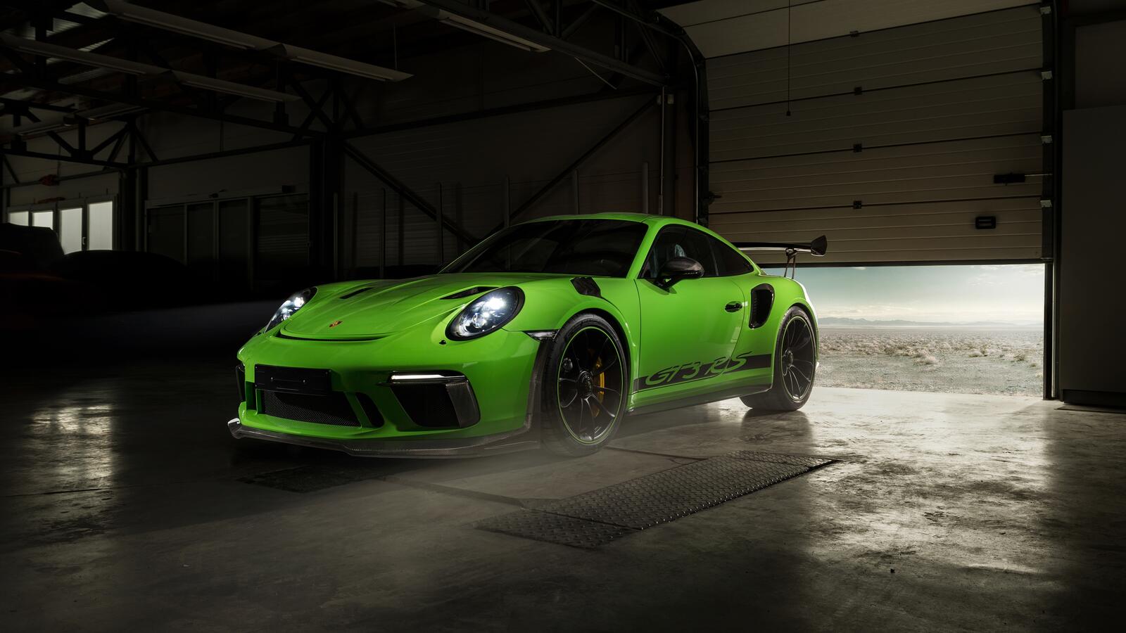 Бесплатное фото Porsche 911 GT3 RS зеленого цвета в ангаре