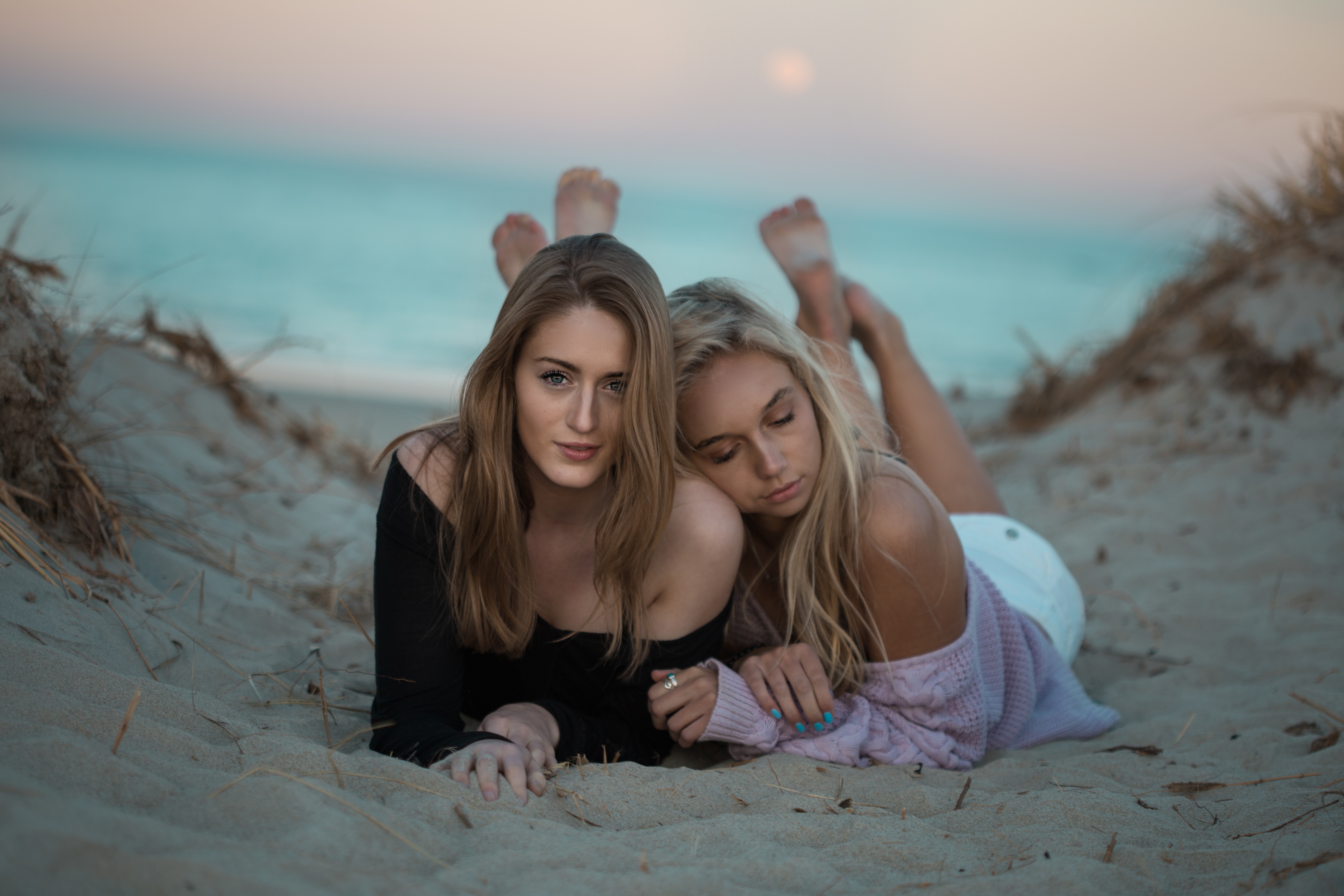 两个女孩躺在沙滩上