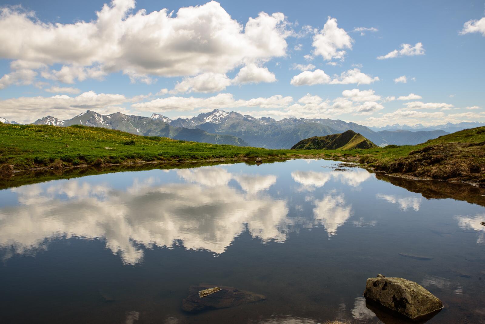 Free photo A lake in the mountains reflects the sky with clouds