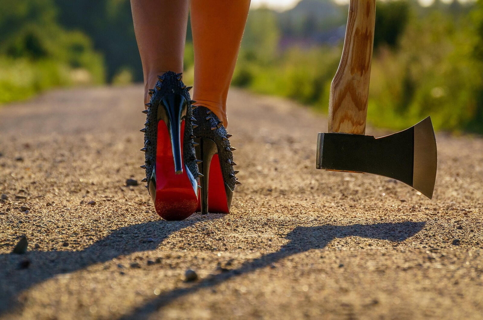 Бесплатное фото Девушка в черных туфлях с красной подошвой и топором