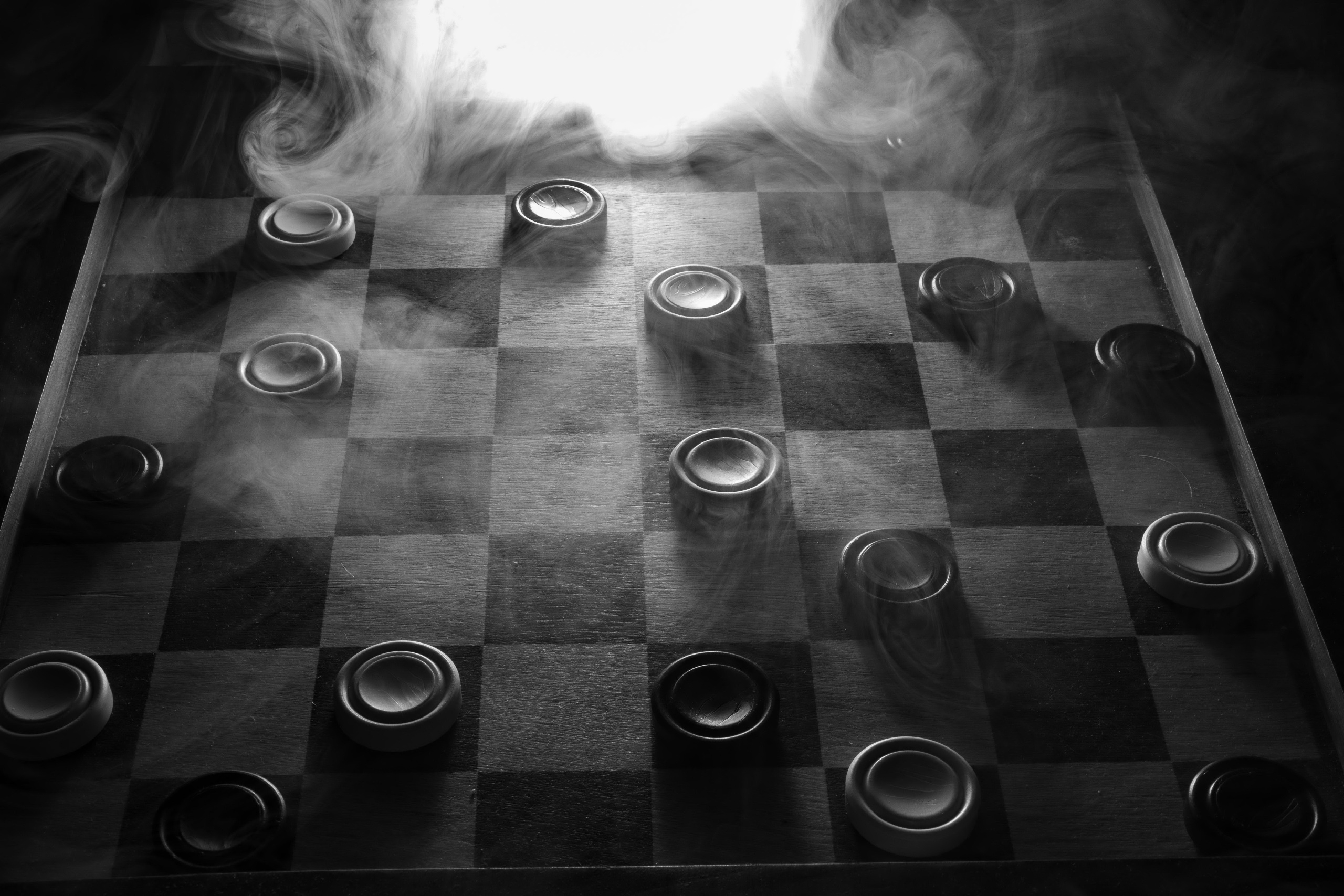 Бесплатное фото Доска с шашками на монохромном фото в дыму