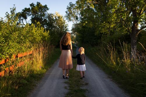 Мама с дочкой гуляют по деревенской дороге
