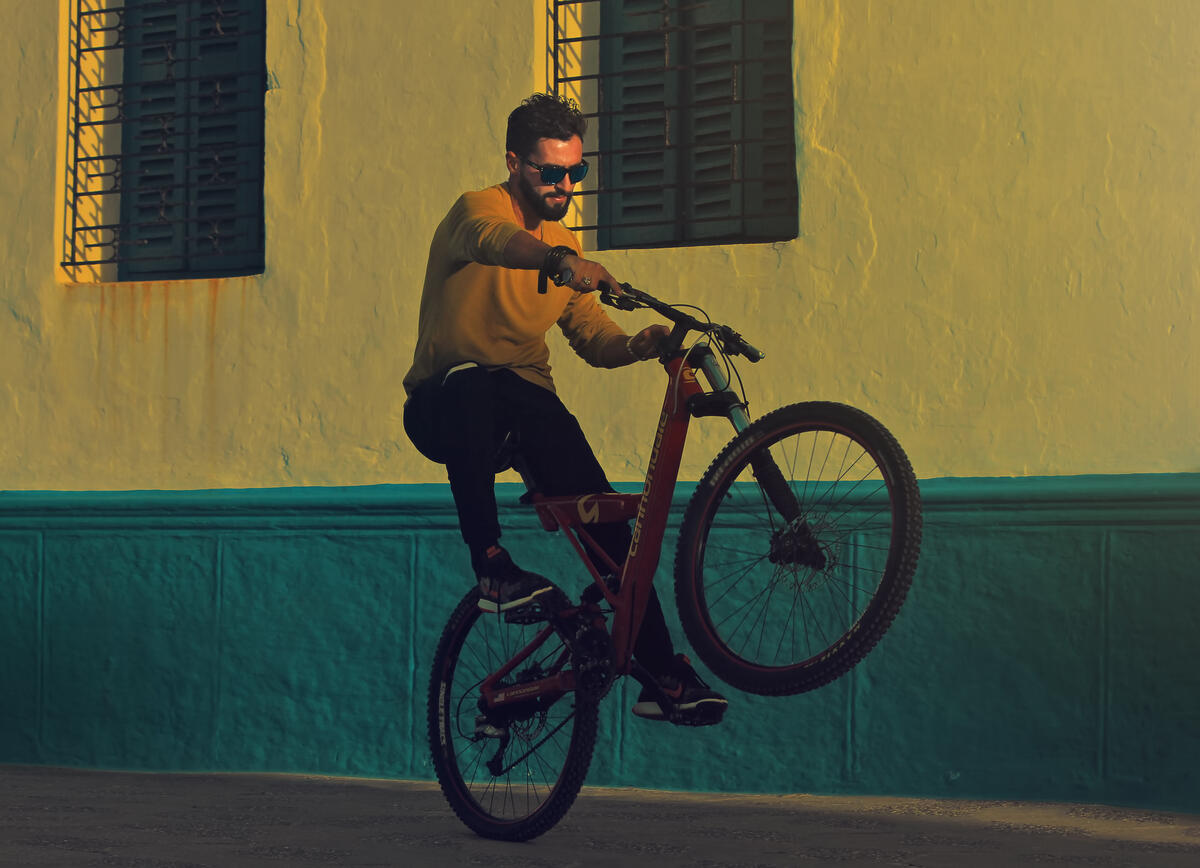 Мужчина на велосипеде едет на заднем колесе