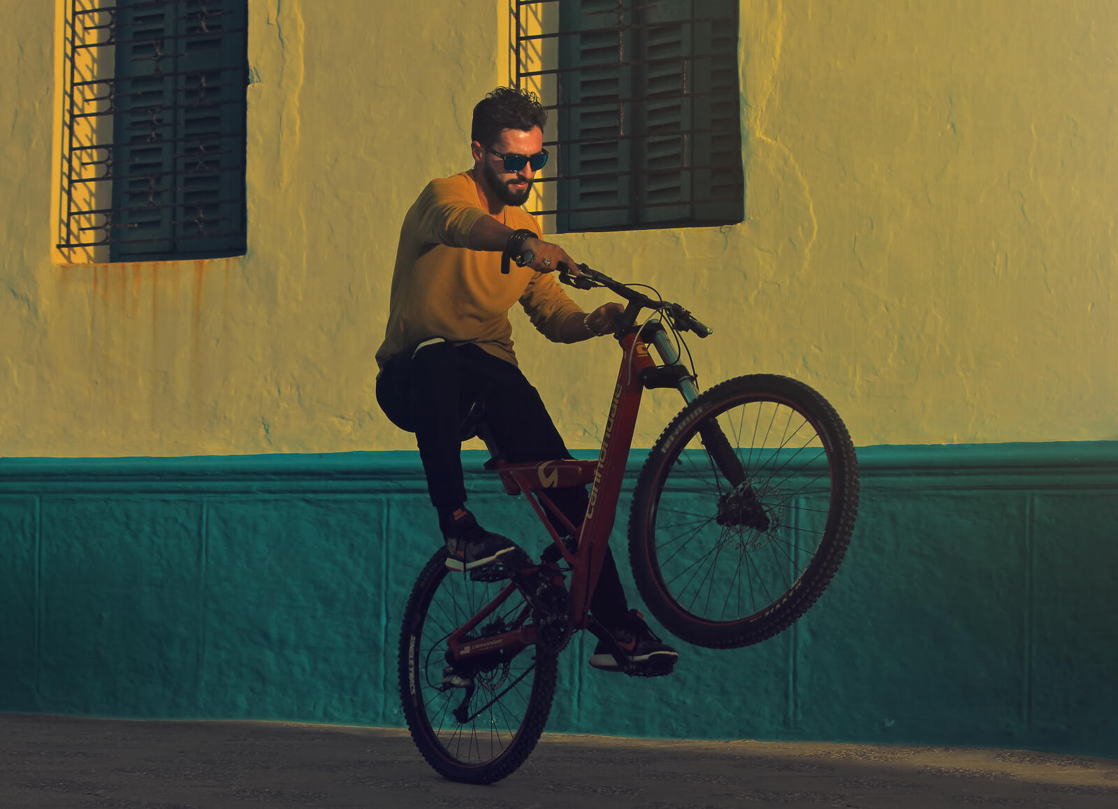Бесплатное фото Мужчина на велосипеде едет на заднем колесе