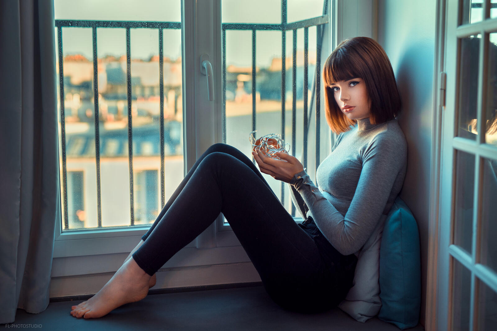 Free photo A beautiful brunette with short hair sits by the window