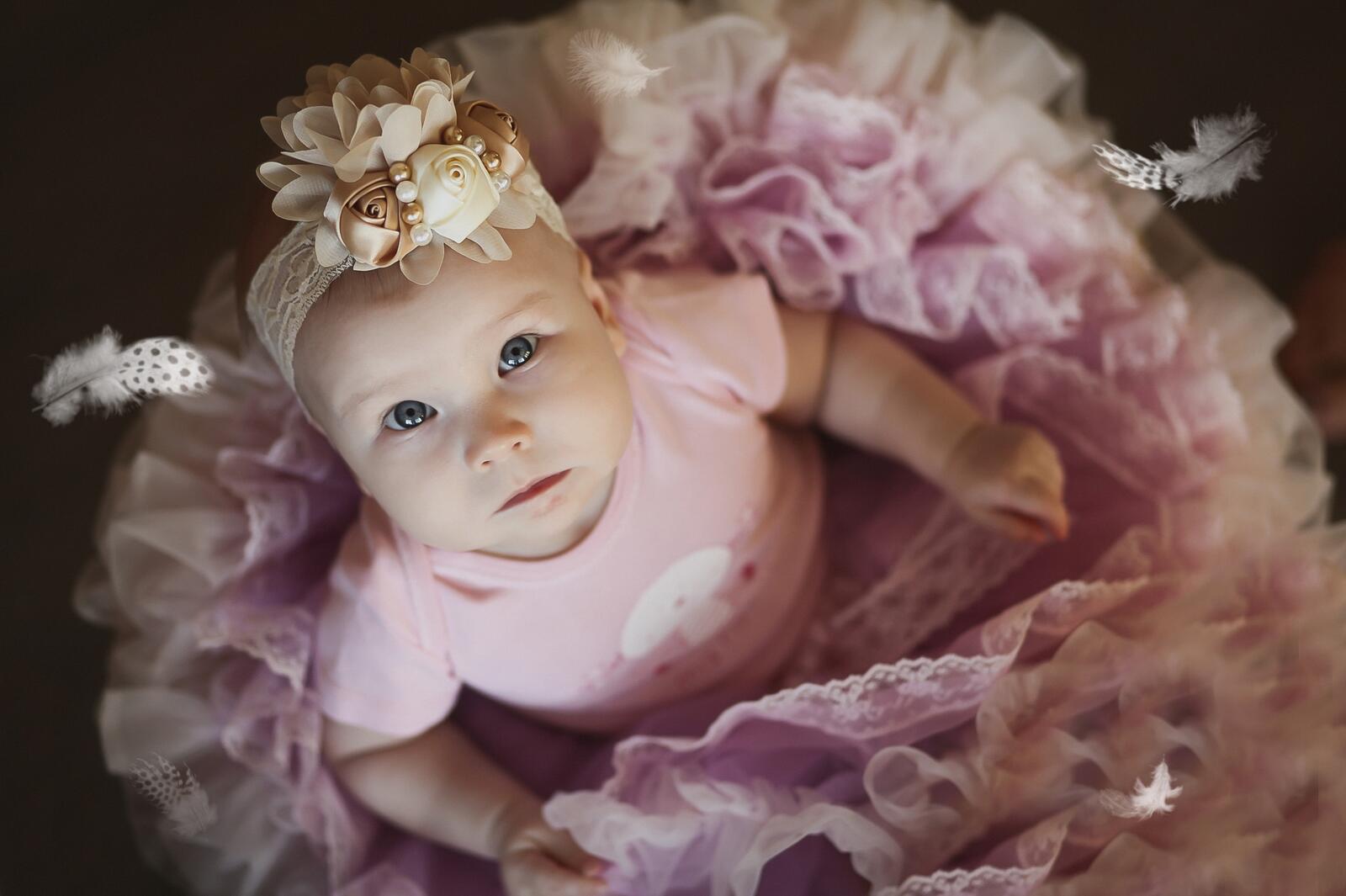 Free photo A baby girl in a bouffant dress looks up