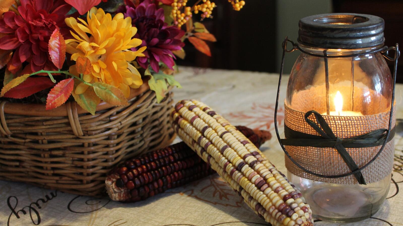 Бесплатное фото Плоды кукурузы рядом с корзиной цветов