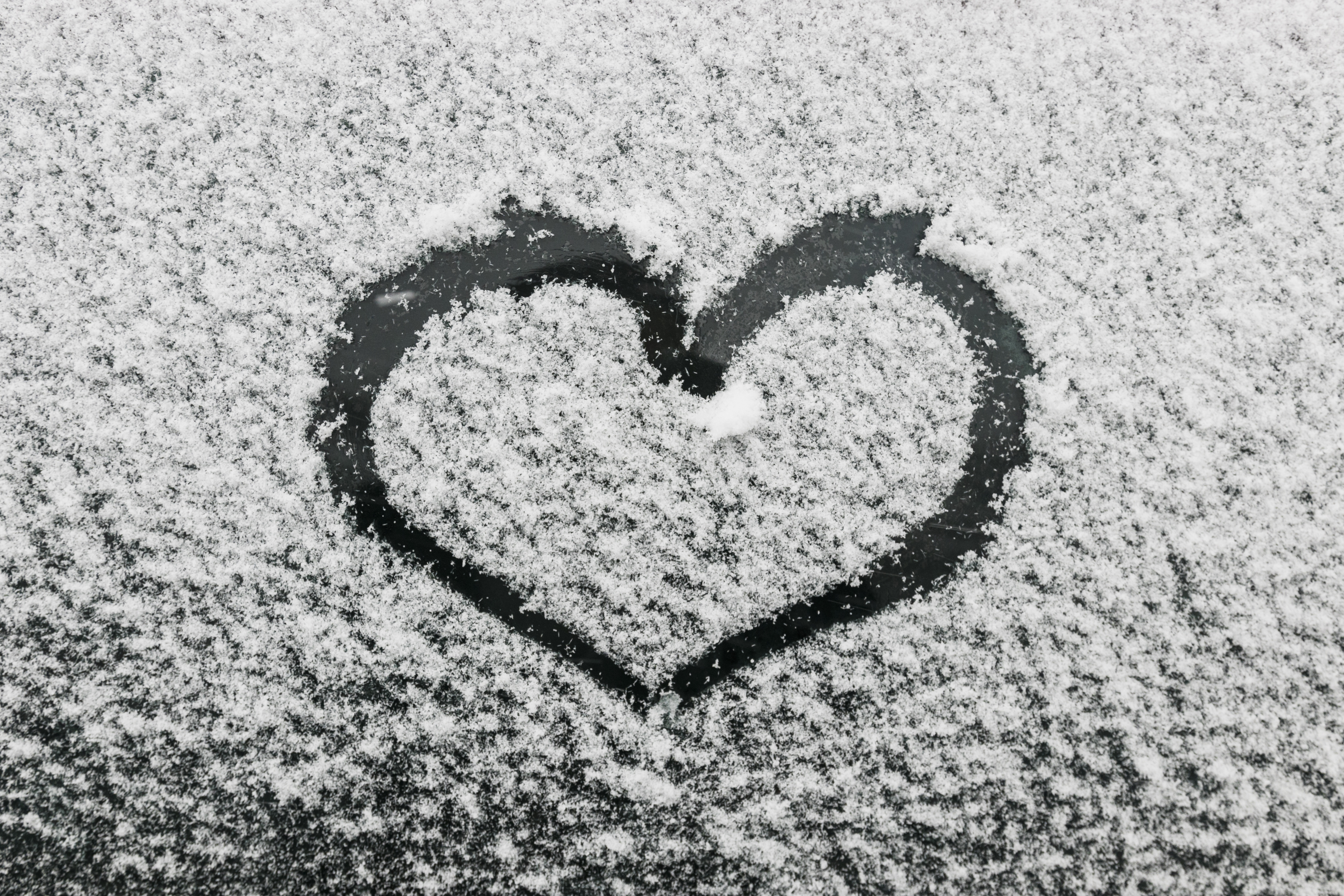 免费照片在冰湖岸边用雪画出一颗心