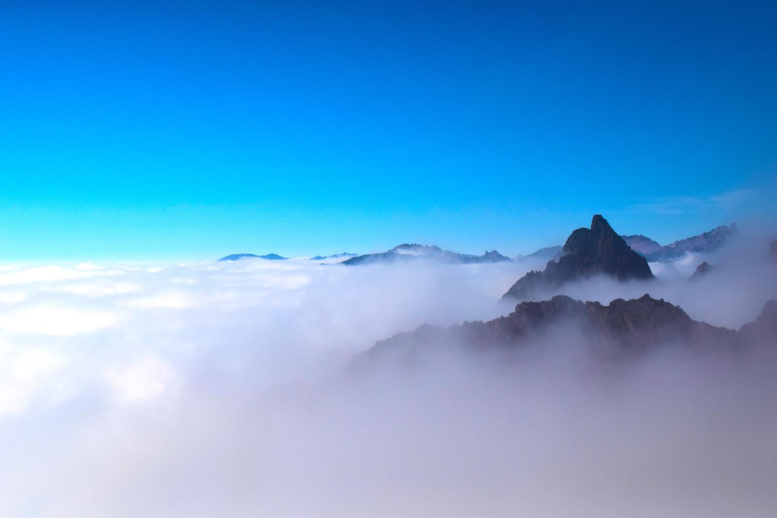Free photo Flying over the clouds with mountain tops