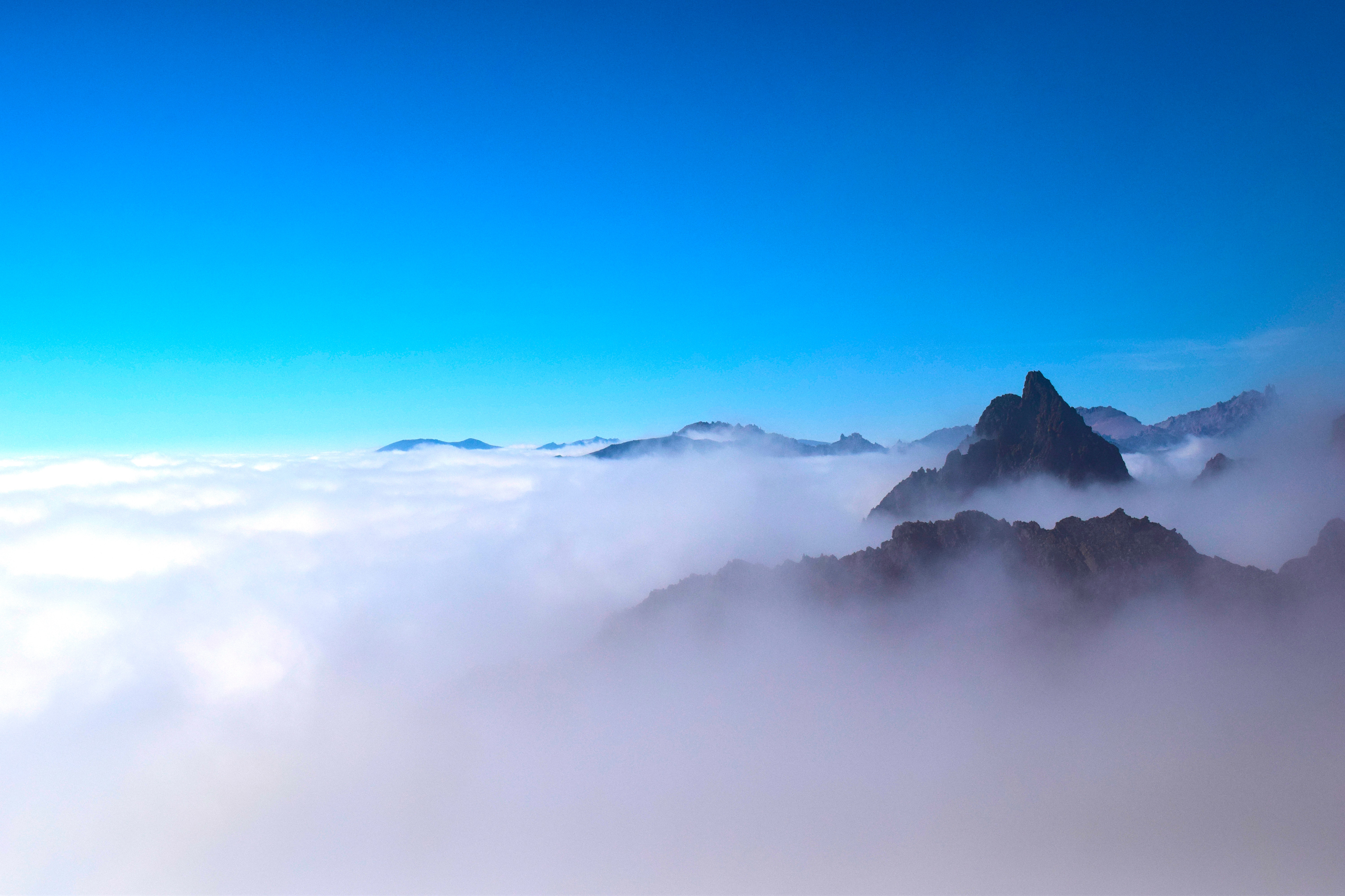 Полет над облаками с вершинами гор · бесплатная фотография