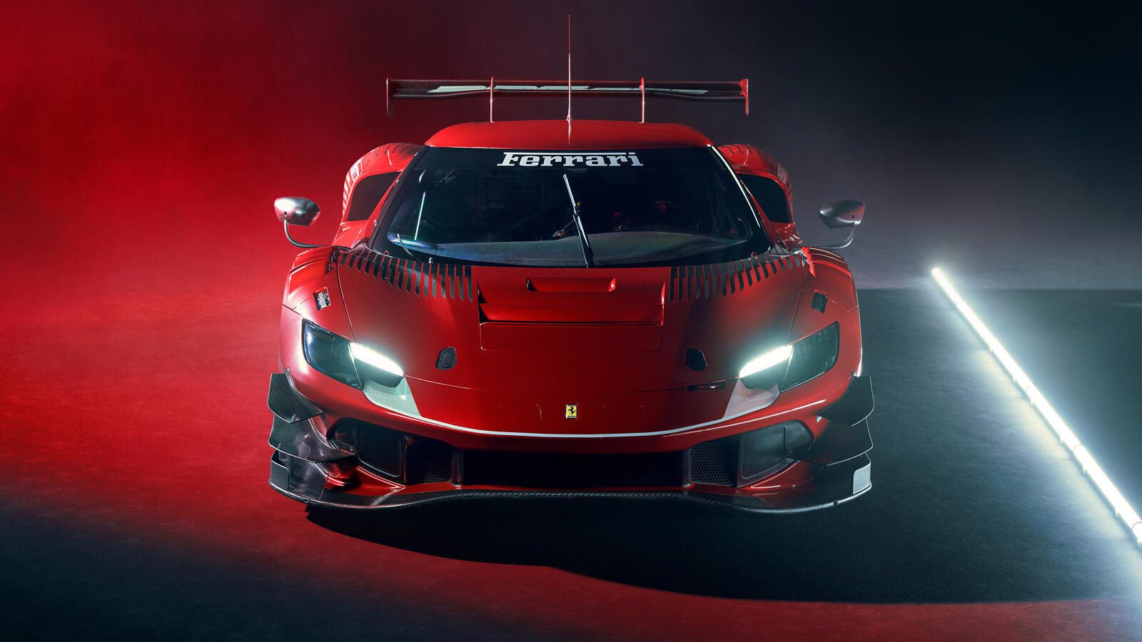 Free photo Red Ferrari 296 GT3 with headlights on 2022