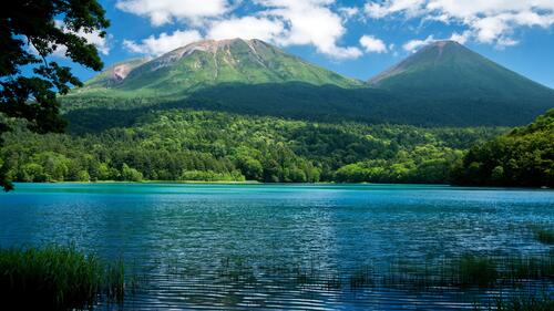 Красивое голубое озеро на фоне гор похожих на вулкан