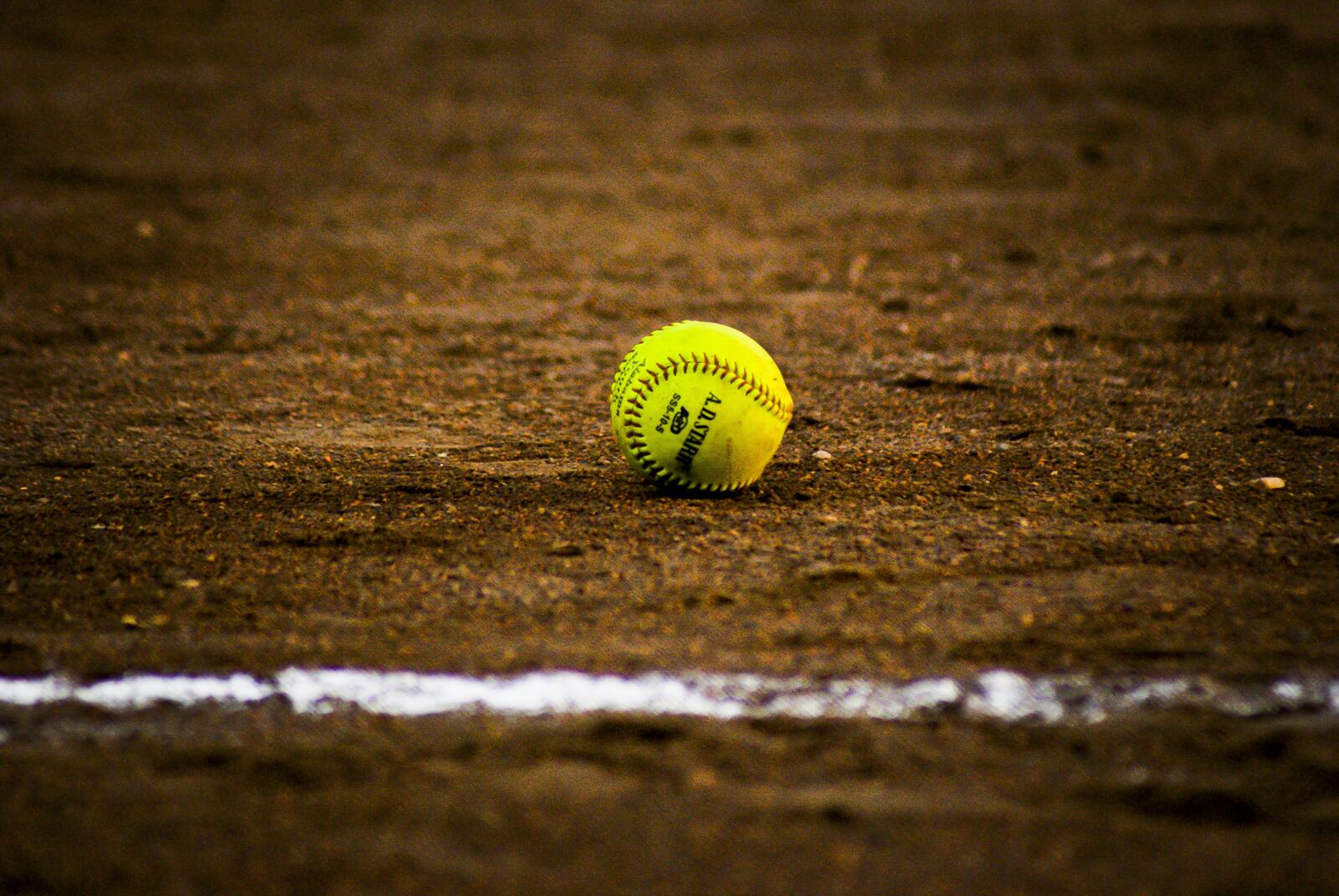 Бесплатное фото Желтый бейсбольный мячик на песке