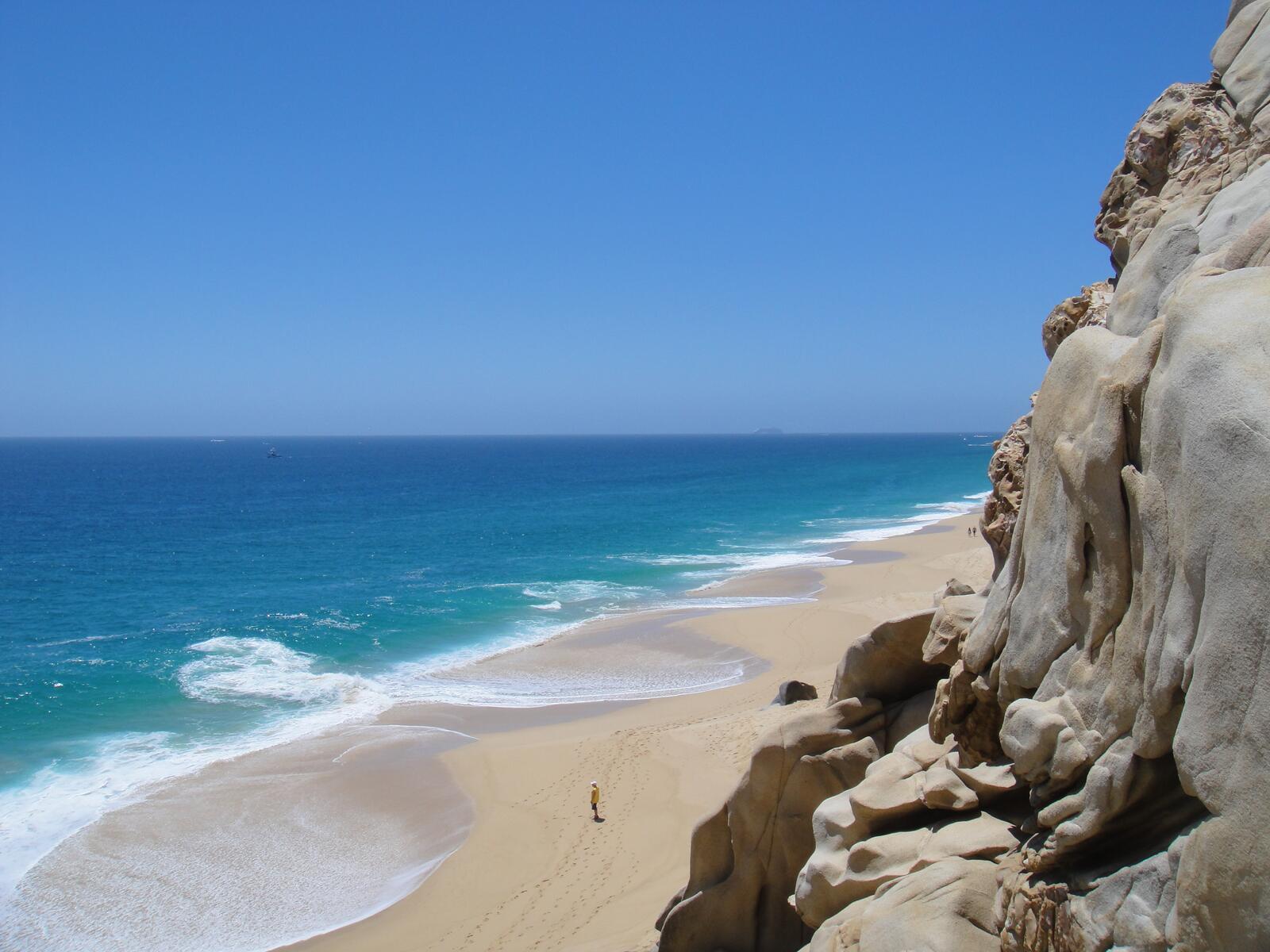 Бесплатное фото Большая скала у песка на берегу моря