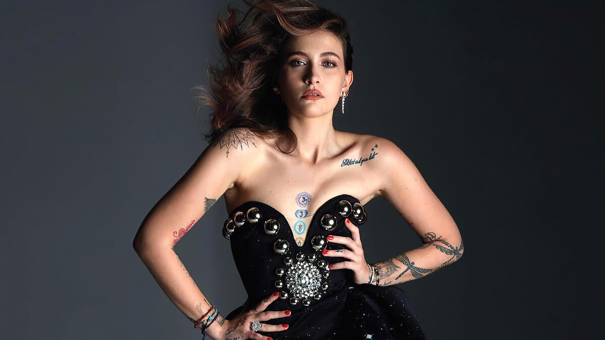 Paris Jackson in a black dress with body tattoos