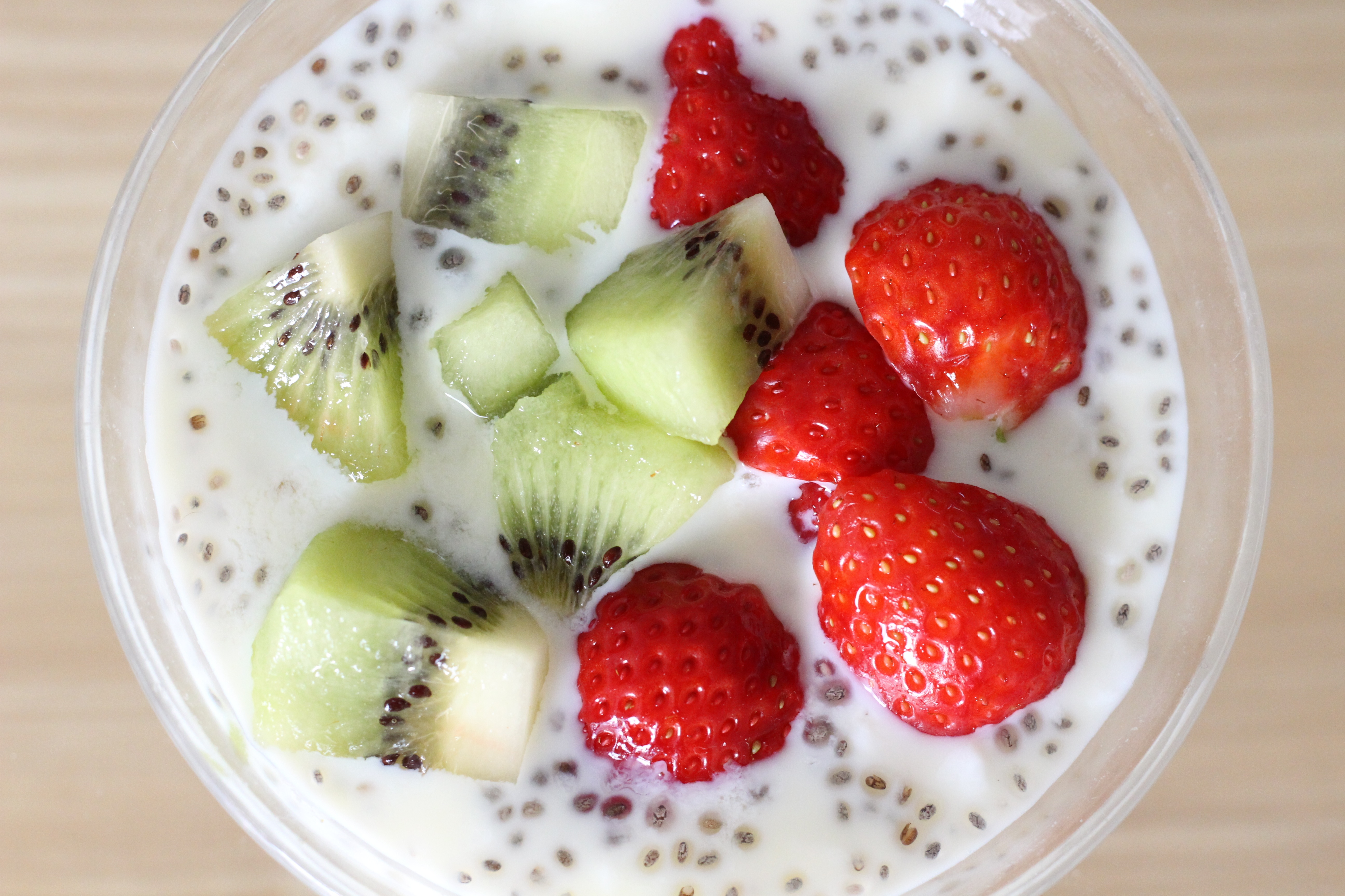 Free photo Milk yogurt with kiwi pieces and strawberries