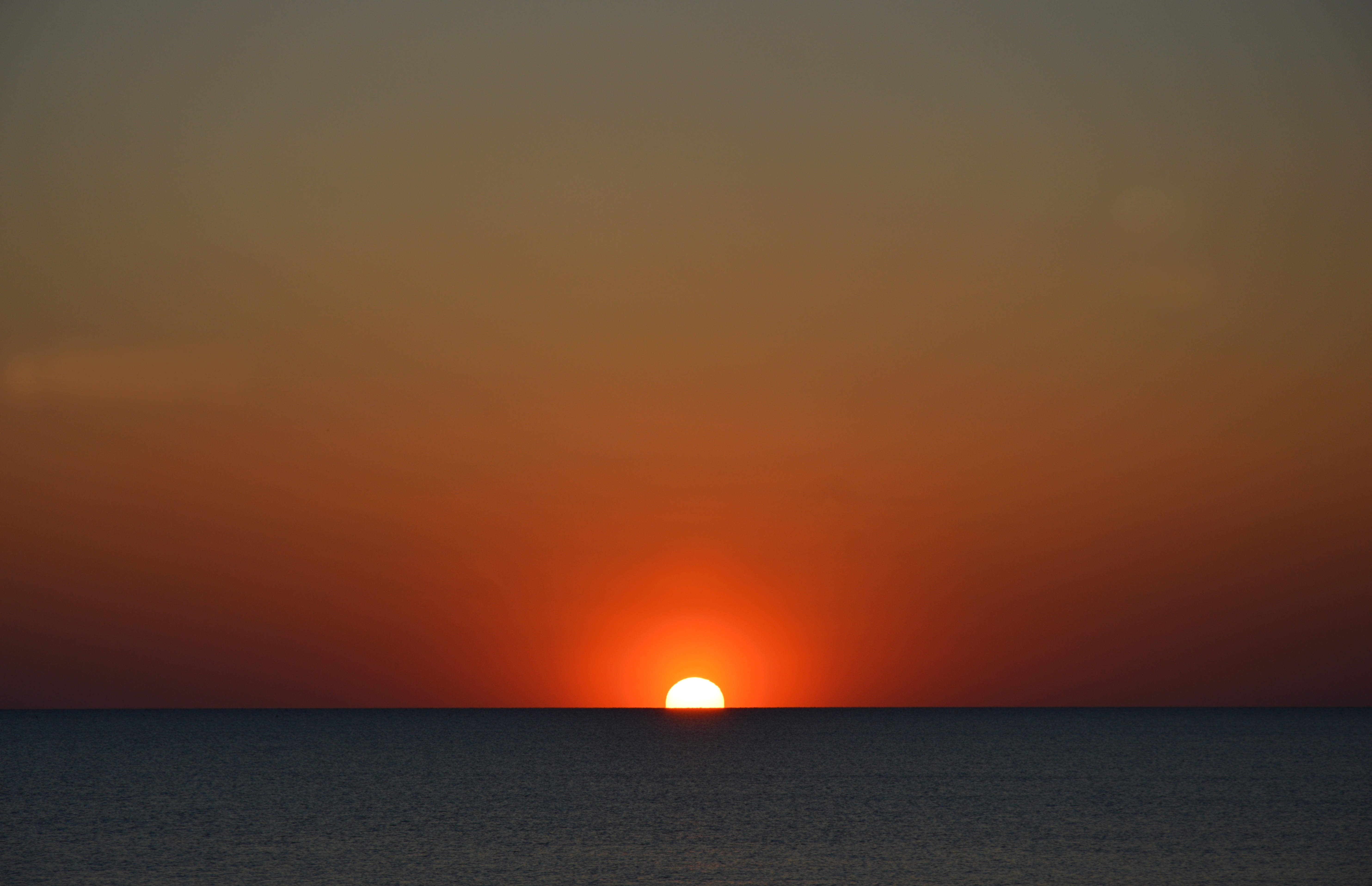 Free photo The red sun goes into the sea horizon