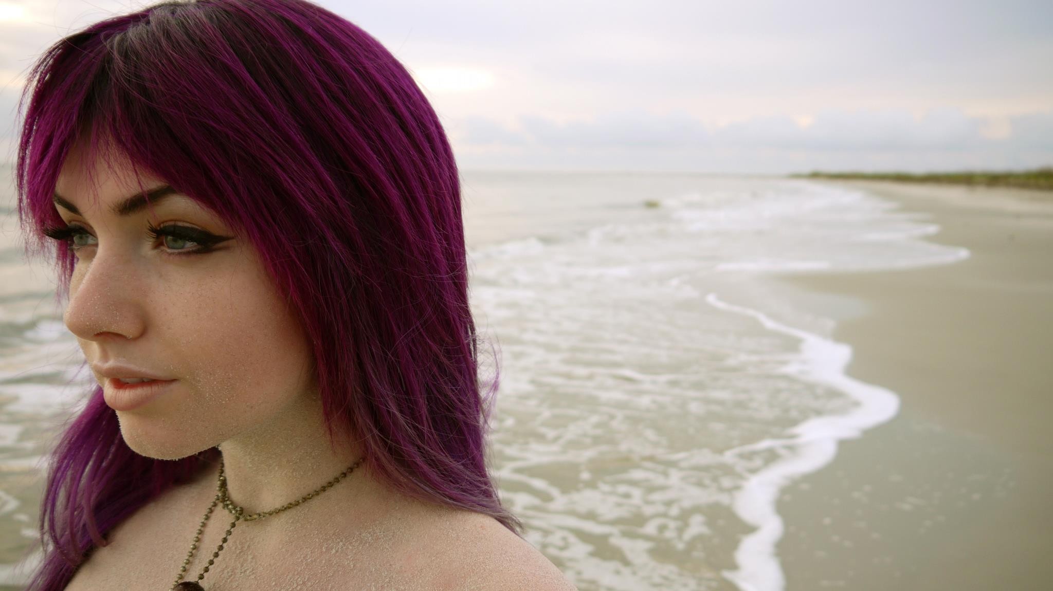 A girl with red hair on the seashore