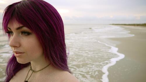A girl with red hair on the seashore