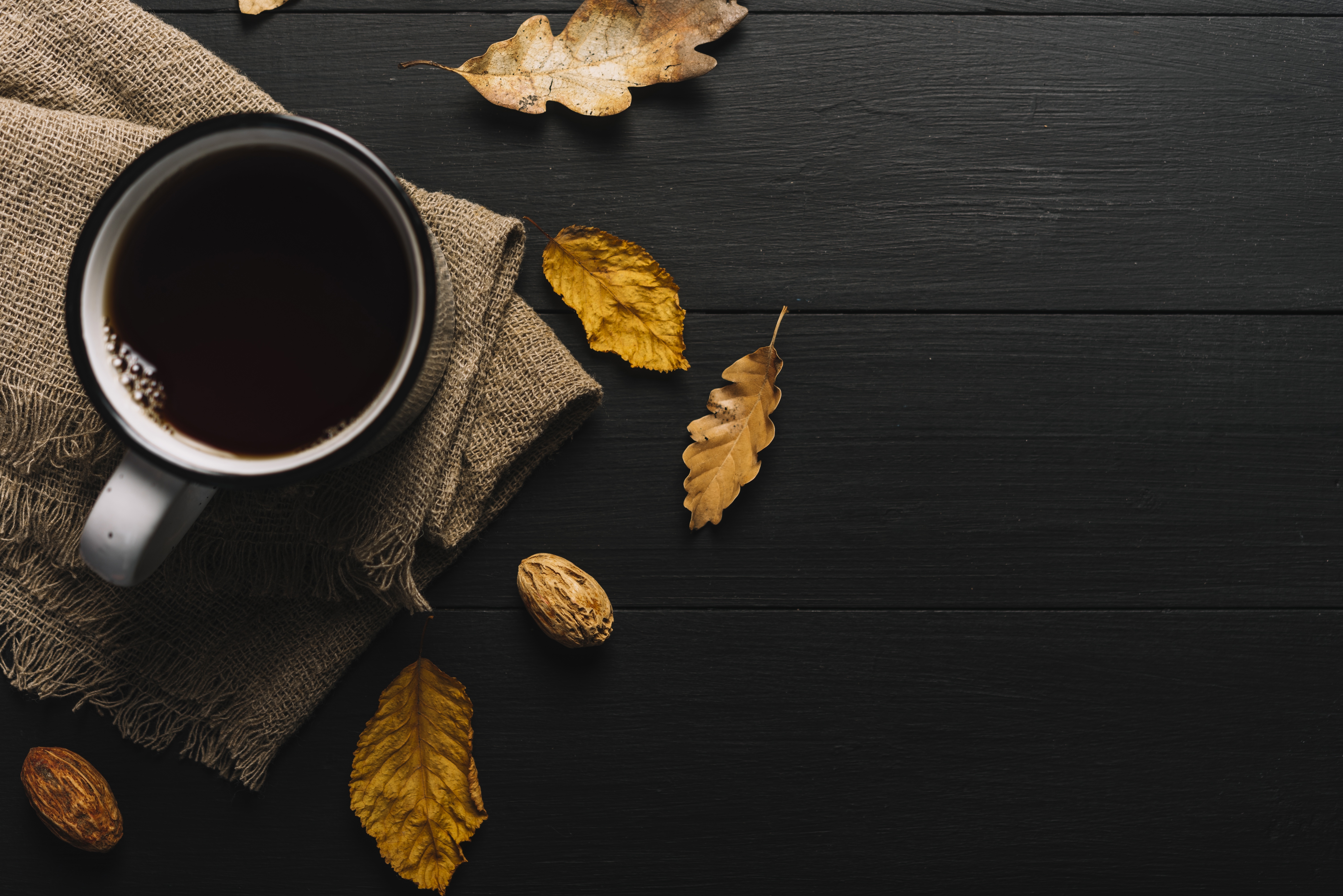 秋天的咖啡杯，桌子上有叶子