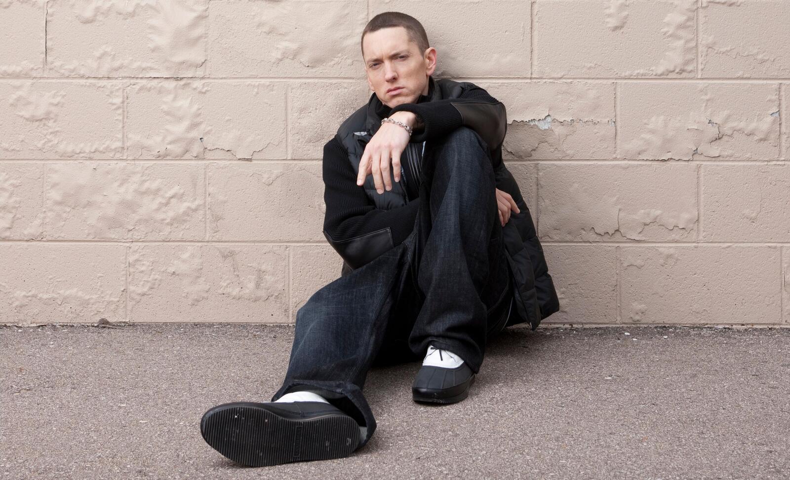 Free photo Rapper Eminem sits against the wall