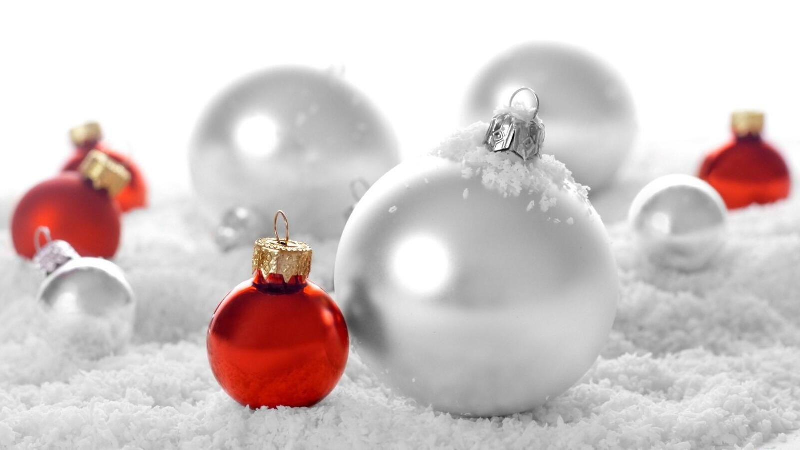 Бесплатное фото Белые и красные новогодние игрушки на снегу