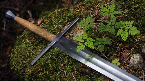 Средневековый меч лежит на траве