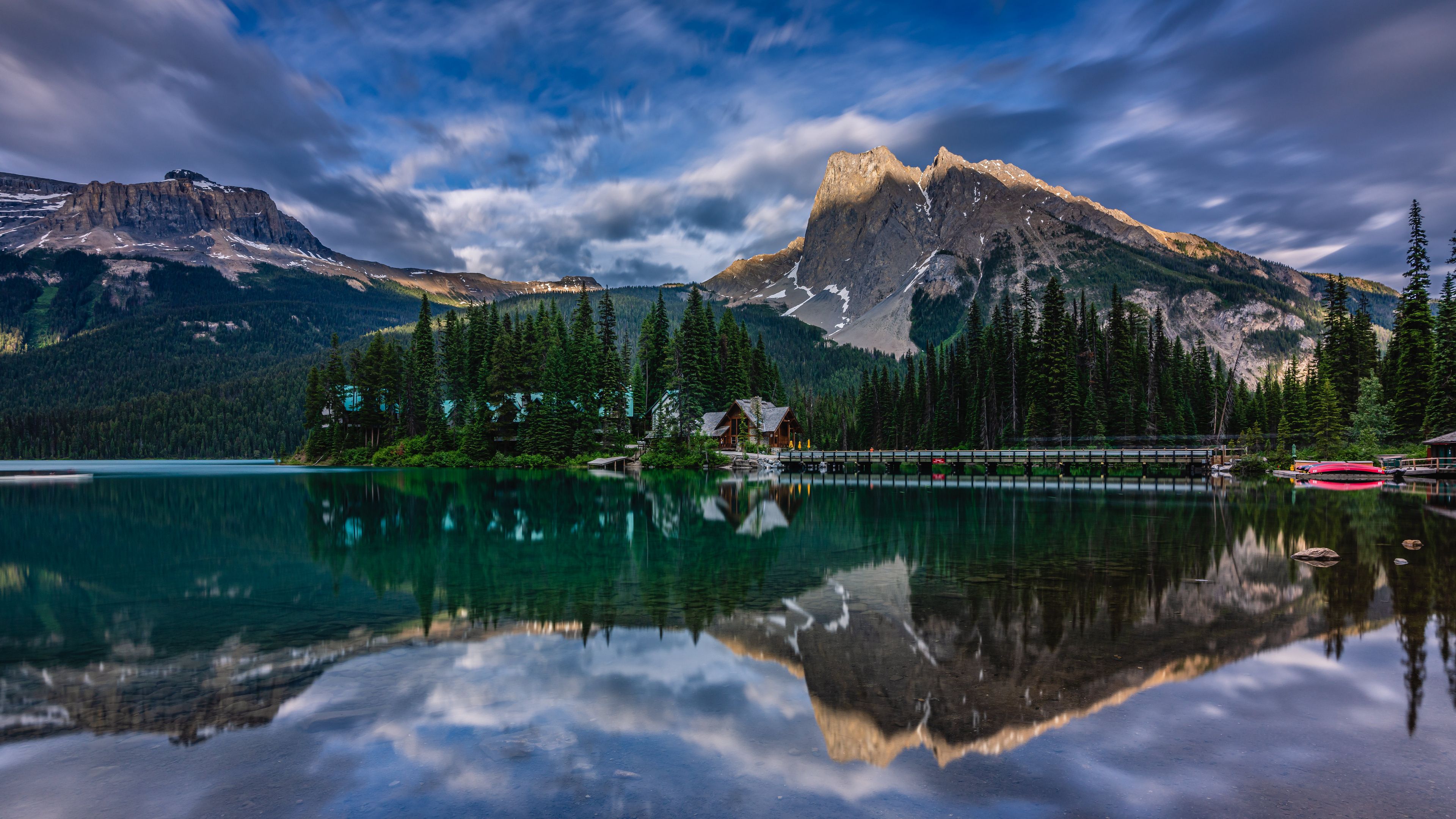 Free photo A dark green lake with a reflection of the mountains in it