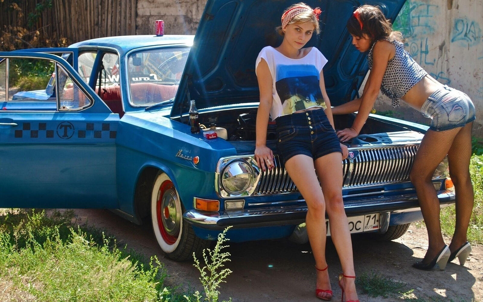 Free photo Two girls next to the blue Volga