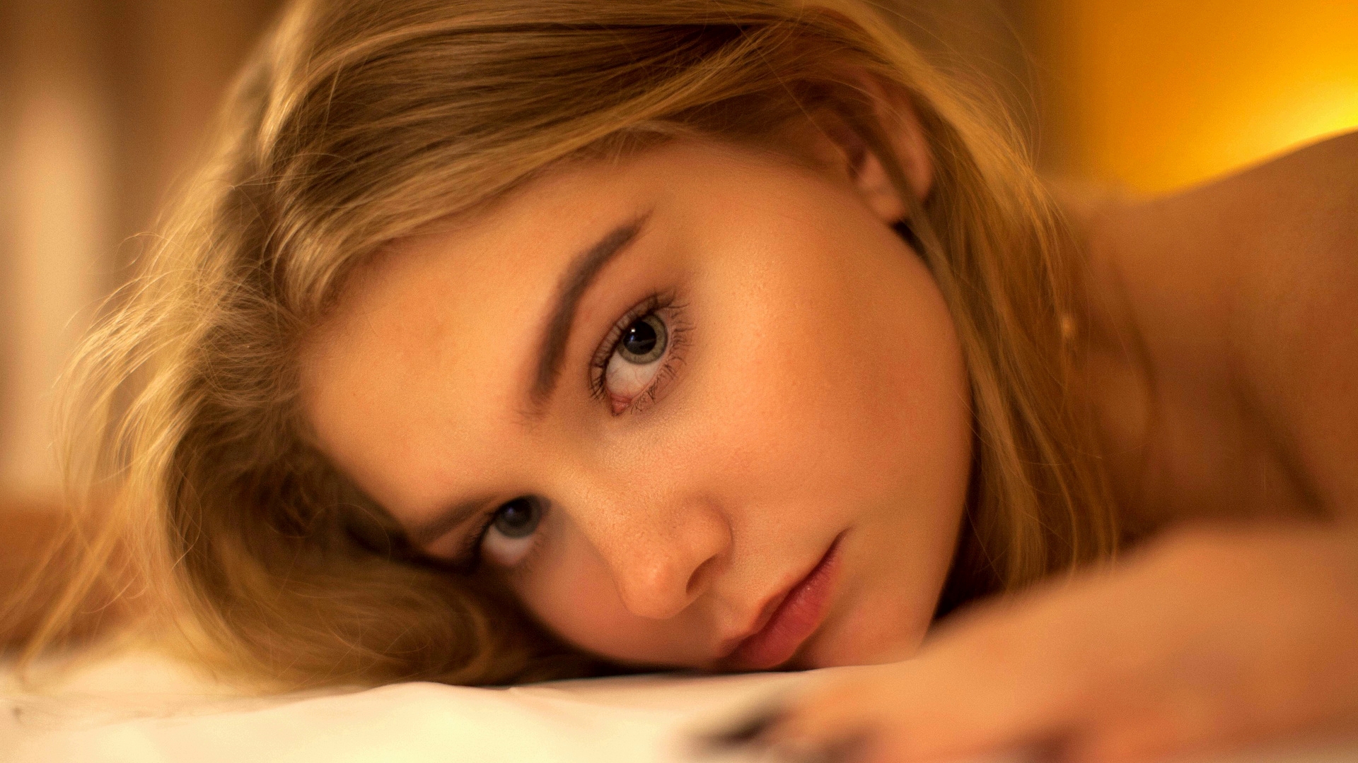 Free photo Portrait of a girl lying on a bed