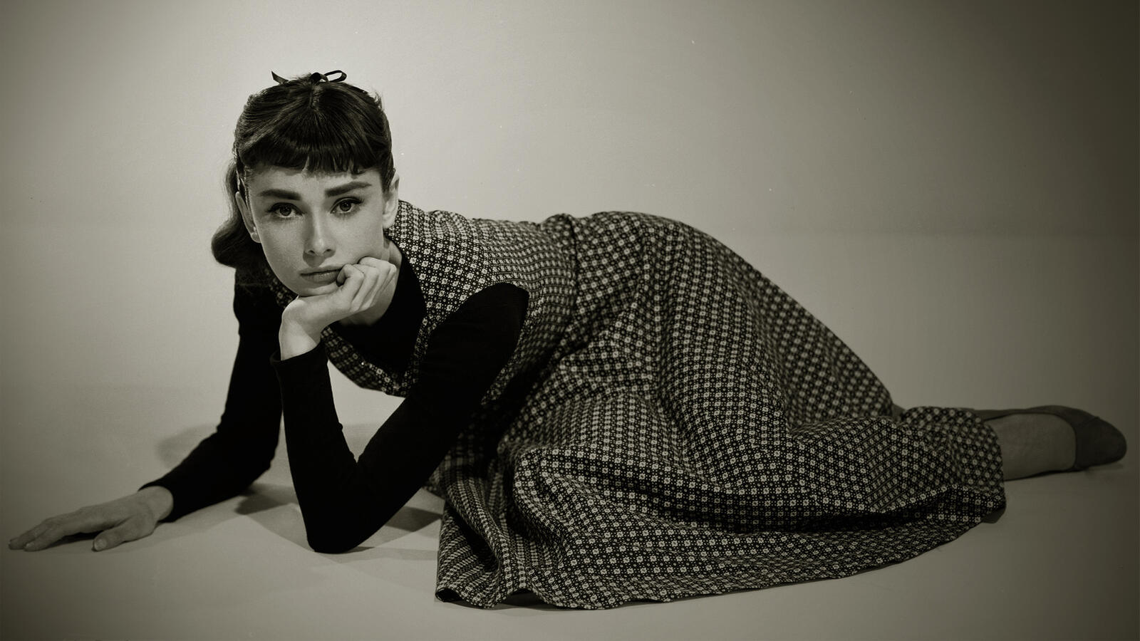 Free photo Actress Audrey Hepburn lying on the floor.