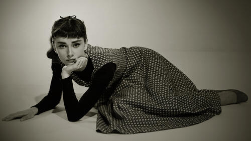 Actress Audrey Hepburn lying on the floor.