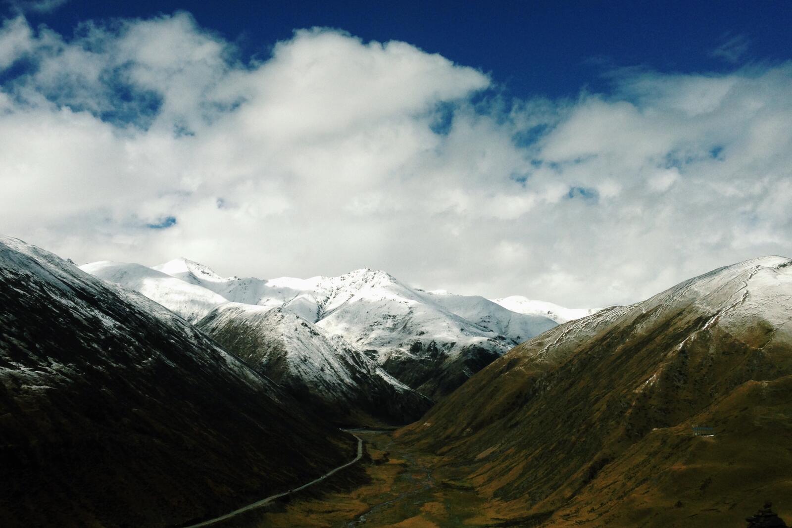 Бесплатное фото Зеленые холмы со снежными вершинами